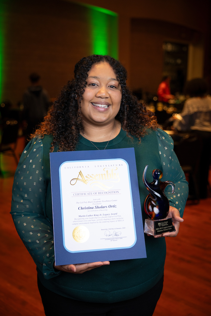 Christina Sholars Ortiz holds her award certificate and trophy at the MLK Legacy event in January. 