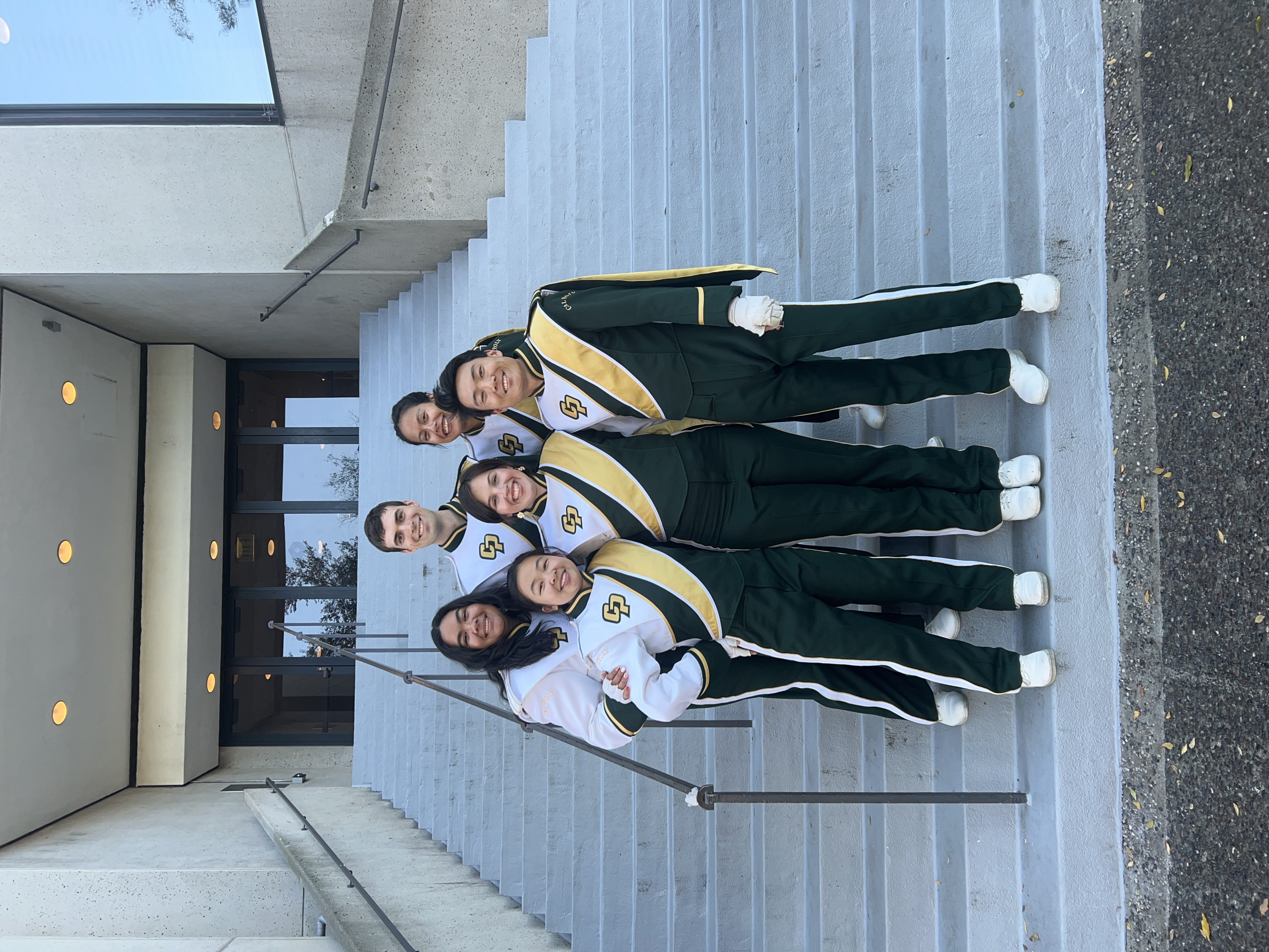 Six clarinet players in Mustang Band pose for a photo on a staircase to commemorate their senior year.