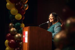 MLK Award winner Christina Sholars Ortiz smiles at the audience from the podium during the MLK Legacy event.
